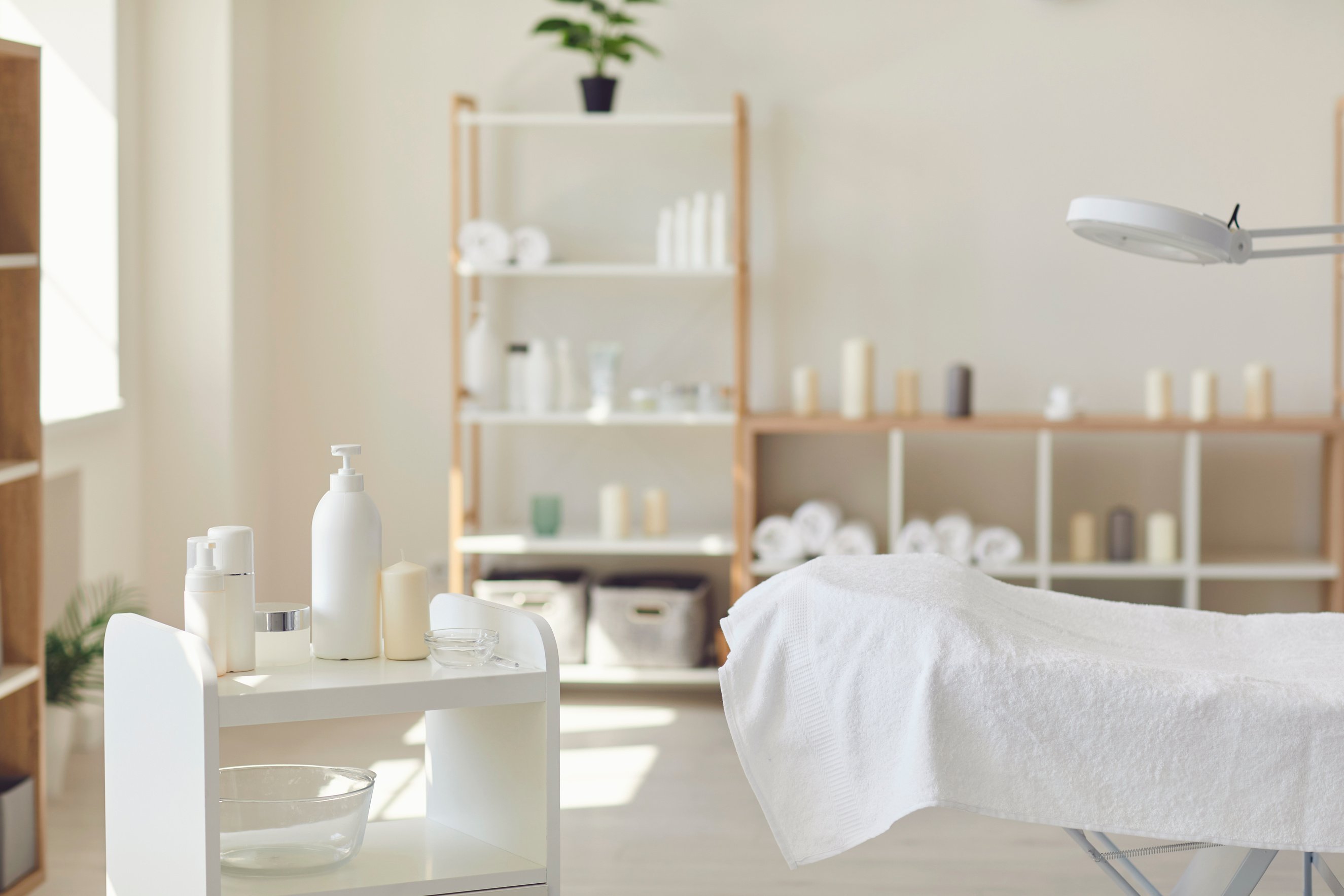 Spa Salon Room with Set of Natural Skincare Products, Empty Bed and Fresh Towels
